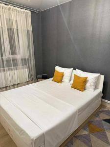 ein großes weißes Bett mit zwei gelben Kissen darauf in der Unterkunft BruD ԲՐՈՒԴ in Debed
