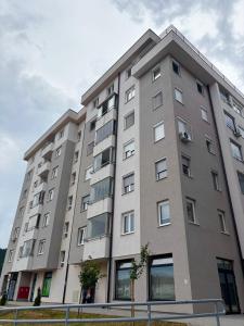 a large gray building with windows on a street at Apartman Pale - Biljana in Pale