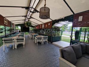a restaurant with tables and chairs and a patio at Best Lido Hotel in Timişoara