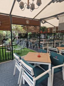 a patio with a wooden table and chairs at Best Lido Hotel in Timişoara