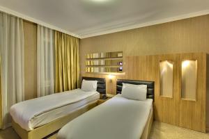 ein Hotelzimmer mit zwei Betten und einem Schreibtisch in der Unterkunft Antroyal Hotel in Antalya