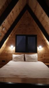a bed in a wooden room with a window at Şimal Bungalov in Samsun +7 photos