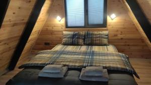 a bed in a cabin with two pillows and a window at Şimal Bungalov in Samsun