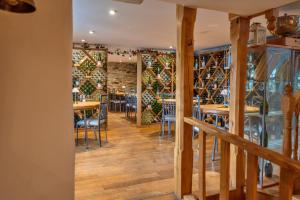 a dining room with tables and chairs and a wall of wine bottles at Finest Retreats - Jabajak Vineyard in Whitland