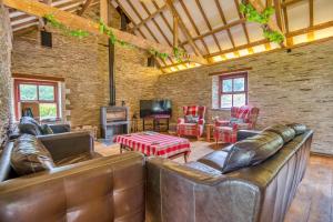 a living room with leather furniture and a tv at Finest Retreats - Jabajak Vineyard in Whitland