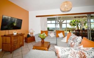 a living room with a couch and a flat screen tv at THE BAY in Trou d'Eau Douce