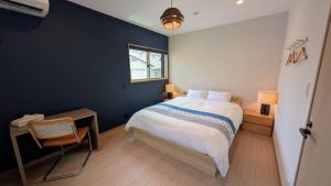 a bedroom with a bed and a chair and a window at Dream Stays HIKARI in Osaka