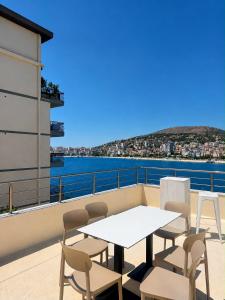 a table and chairs on a balcony with a view of the water at Hotel Barjami in Sarandë