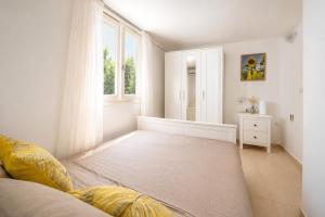 a white room with a bed and a window at Little Villa - walk to the beach in Thessaloniki