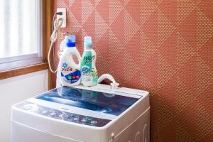 a washing machine with two bottles on top of it at Gran kodachi in Fujikawaguchiko