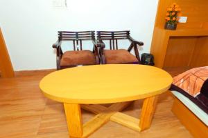 a yellow wooden table in a room with a bed at HOTEL ELiTE in Pānīpat