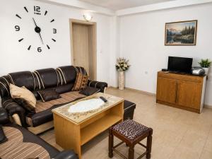 a living room with a couch and a clock on the wall at Tetins'Apartmens in Trpejca