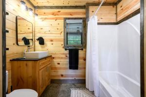 a wooden bathroom with a sink and a tub at Private Escape| Hot tub| Fire Pit| Trail Access in Broken Bow +29 photos
