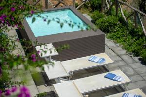 a pool with two chairs and a table and a television at Villa Alba - Amalfi Coast in Amalfi