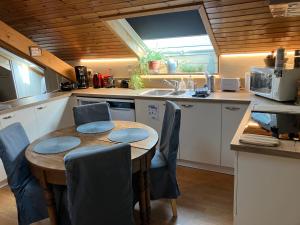 a kitchen with a table and chairs and a sink at Villa Angela, appartement 3 chambres in Ovifat