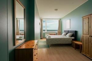 a bedroom with a bed and a mirror and a window at Viinistu Art Hotel in Viinistu