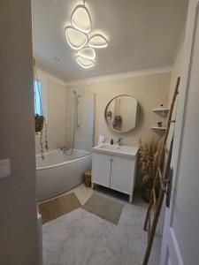 a bathroom with a tub and a sink and a mirror at La Villa Blateiras in Générargues +25 photos