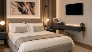 a bedroom with a large bed and a tv at The Captain's Apartments Marina - next to Verbella - Leonardo Academy, MXP in Sesto Calende +5 photos