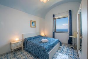 a bedroom with a blue bed and a window at Villa Alba - Amalfi Coast in Amalfi +86 photos