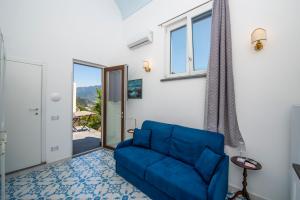 a living room with a blue couch and a window at Villa Alba - Amalfi Coast in Amalfi
