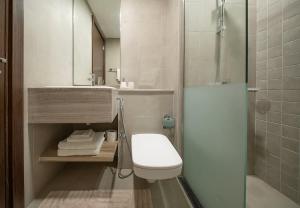 a bathroom with a shower and a toilet and a sink at Stunning Oceanfront Studio Stay - Blue Bay Walk Pool & Gym in Sharjah