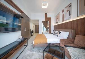 a hotel room with a bed and a couch at Stunning Oceanfront Studio Stay - Blue Bay Walk Pool & Gym in Sharjah