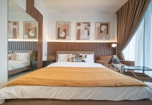 a bedroom with a large bed and a table at Stunning Oceanfront Studio Stay - Blue Bay Walk Pool & Gym in Sharjah