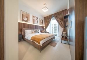 a bedroom with a large bed and a large window at Stunning Oceanfront Studio Stay - Blue Bay Walk Pool & Gym in Sharjah