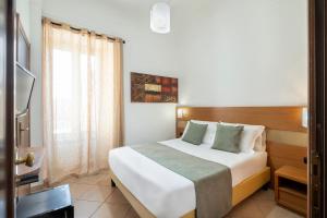 a bedroom with a large white bed with a window at Hotel Moscatello in Rome