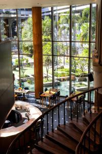 a restaurant with tables and chairs and large windows at Hyatt Delhi Residences in New Delhi +30 photos