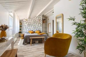 a bedroom with a bed and a yellow chair at Les Chambres De Miloly in La Jarrie