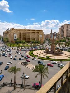 a parking lot filled with cars in a city at Up Town Crown Hotel in Cairo