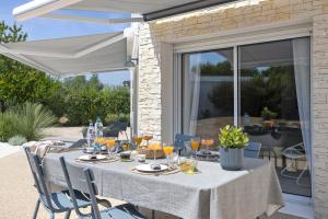 a table under a white umbrella on a patio at Les Chambres De Miloly in La Jarrie