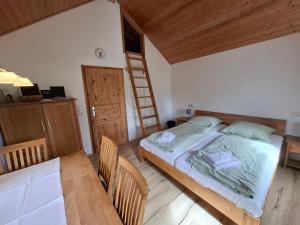 a bedroom with a bed and a table and a ladder at Mitteltalhof in Kaufungen