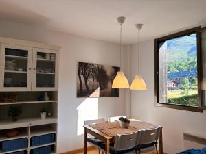 a dining room with a table and chairs and a window at Con encanto, buena ubicación, confort y parking - Aüt 2 in Pla de l'Ermita