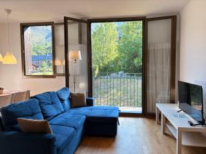 a living room with a blue couch and a large window at Con encanto, buena ubicación, confort y parking - Aüt 2 in Pla de l'Ermita