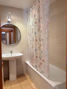 a bathroom with a sink and a shower curtain at Con encanto, buena ubicación, confort y parking - Aüt 2 in Pla de l'Ermita +33 photos