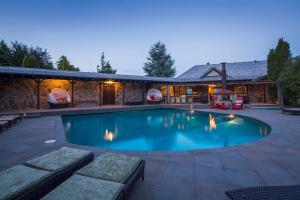 a swimming pool with a patio and a house at Mahu Whenua in Wanaka