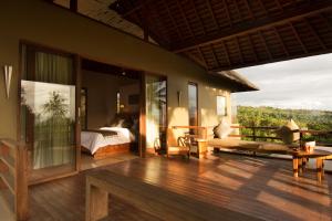 a bedroom with a bed and a balcony with a view at Mora Royal Villa in Senggigi 