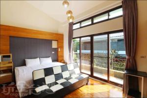a bedroom with a bed and a couch and windows at 三義竺夢園 漫步山林 漫遊桐花 in Sanyi