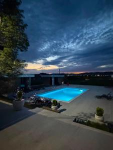 a swimming pool in a yard at night at Elysium2 in Banja Luka