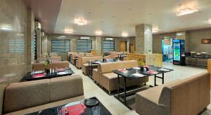 a restaurant with tables and chairs in a room at Ginger Somnath in Somnath