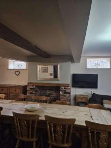 a living room with a large wooden table and chairs at The Holmes Barn - Sleeps 16 - Pet friendly in Buxton