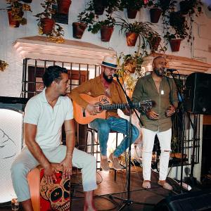 a group of three men in a room with a guitar at Hotel La Chiquita in Córdoba