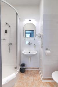 a white bathroom with a sink and a shower at Penzion Janoštík in Rožnov pod Radhoštěm +67 photos