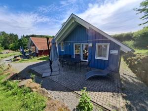 a blue tiny house with a table and an umbrella at Mitteltalhof in Kaufungen