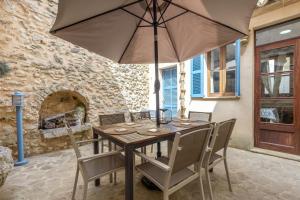 a wooden table with chairs and an umbrella at Can Vallori in Sencelles