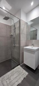 a bathroom with a glass shower with a sink and a toilet at The Loxwood Premier Suites in Accra