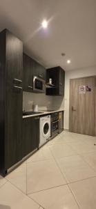 a kitchen with a washing machine and a microwave at The Loxwood Premier Suites in Accra +5 photos