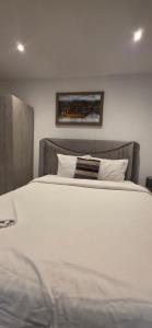 a bedroom with a large bed with white sheets and pillows at The Loxwood Premier Suites in Accra